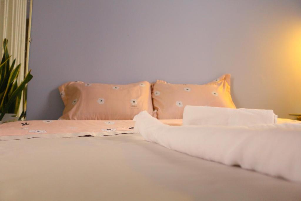 ein Bett mit weißer Bettwäsche und Kissen darauf in der Unterkunft Keydeo Homestay - Phan thiet in Phan Thiet