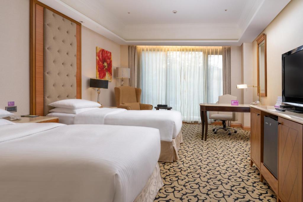 a hotel room with four beds and a television at E-DA Royal Hotel in Dashu