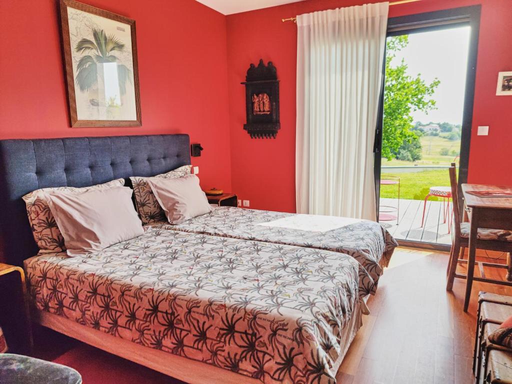 a bedroom with a bed with red walls and a window at la Palisse in Peaugres