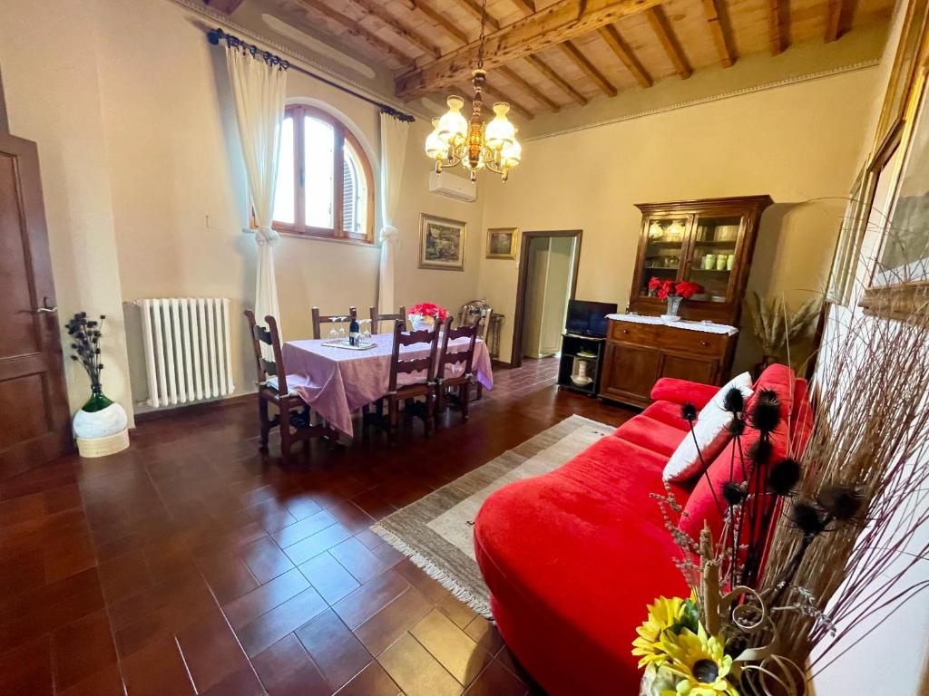 sala de estar con sofá rojo y mesa en La Torre di Caprera, en Siena