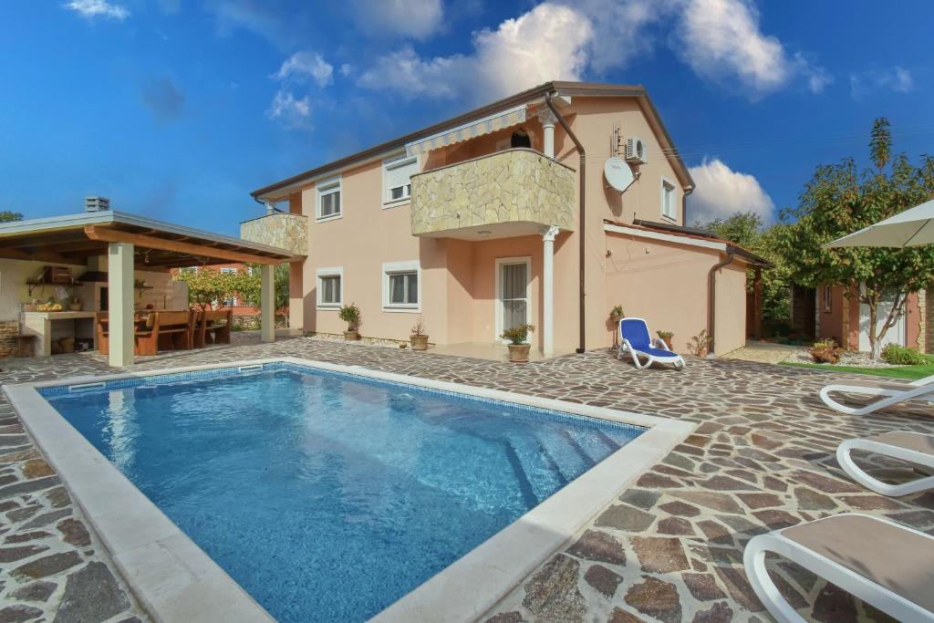 a villa with a swimming pool and a house at Holiday House Amna in Kaldanija