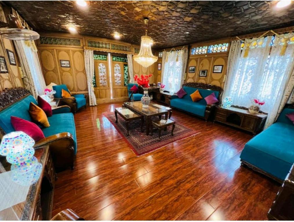 una sala de estar con sofás azules y una mesa. en The Hayat Group Of Houseboats en Srinagar