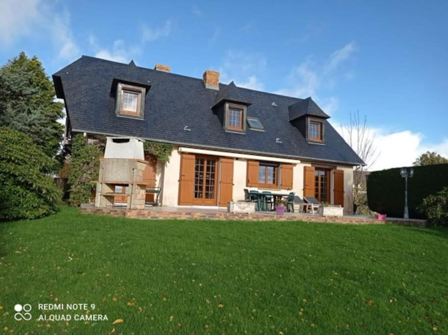 uma casa com um telhado num relvado verde em LA BRUVÉCA Octeville s/Mer em Octeville-sur-Mer