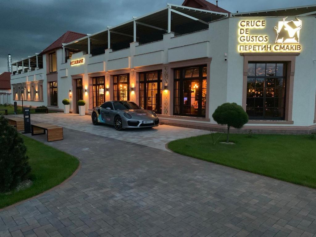 a car parked in a parking lot in front of a hotel at Cruce de Gustos in Ivano-Frankivsʼk