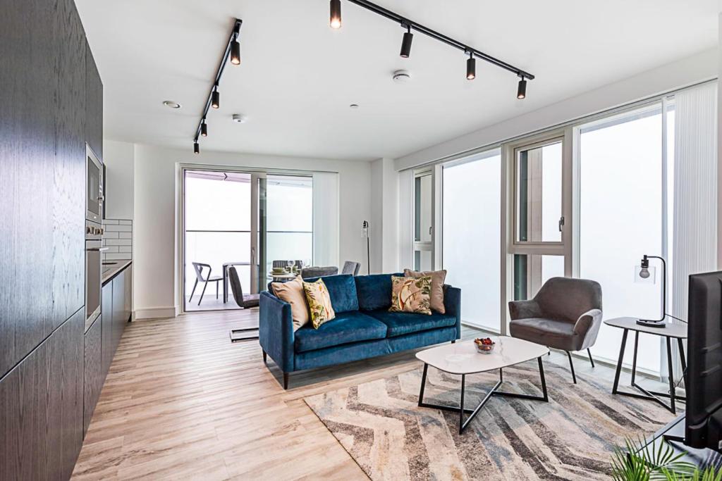 a living room with a blue couch and a table at Modern Flat with City View in Acton in London