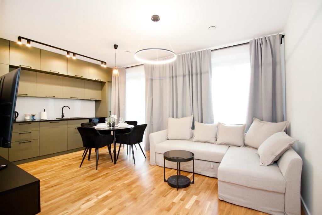 a living room with a white couch and a table at Apartamenty LAGOM in Siedlce