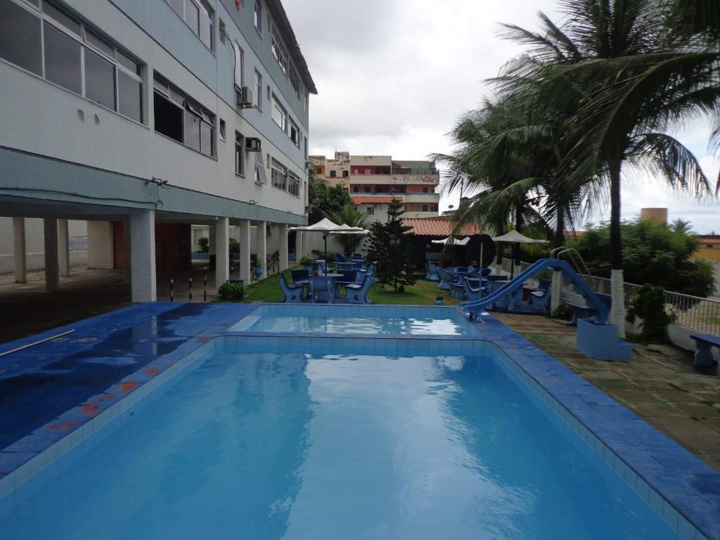 uma grande piscina azul ao lado de um edifício em Condomínio Caribe Fortaleza CE em Caucaia