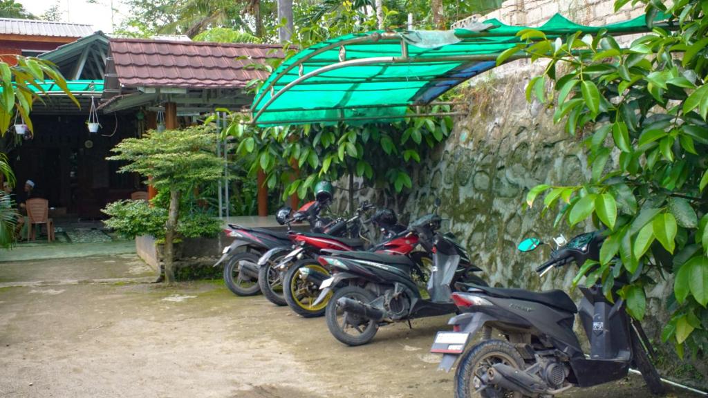 a row of motorcycles parked next to a stone wall at Goa Walet Cottage in Praya