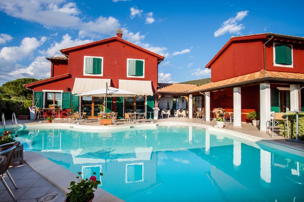 una casa e una piscina di fronte a una casa di Hotel La Posta di Torrenova a Orbetello