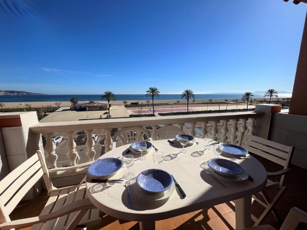 una mesa en un balcón con vistas a la playa en Basic Comfort Apartment Gran Reserva Platja 0071, en Empuriabrava