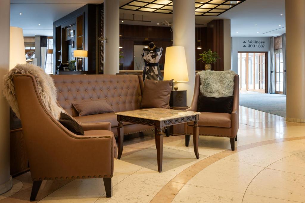 a lobby with chairs and a couch and a table at Arabella Jagdhof Resort am Fuschlsee, a Tribute Portfolio Hotel in Hof bei Salzburg
