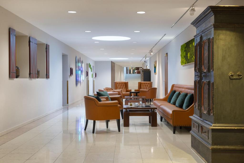 a lobby with couches and a table and chairs at Arabella Jagdhof Resort am Fuschlsee, a Tribute Portfolio Hotel in Hof bei Salzburg