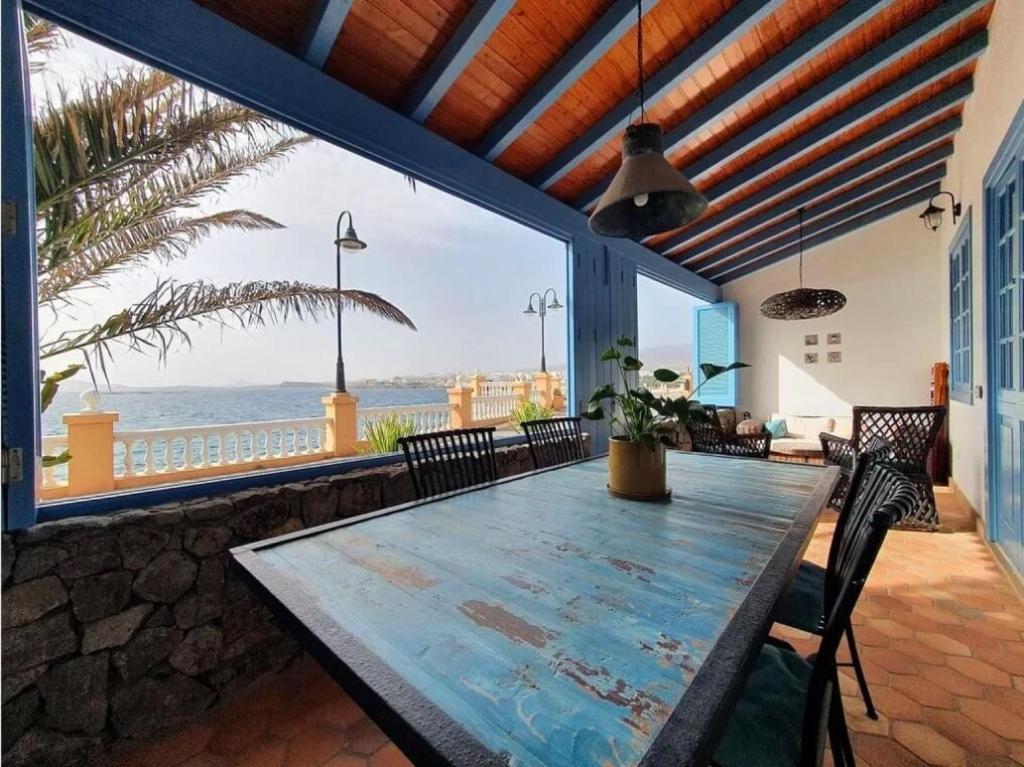comedor con mesa y vistas al océano en Villa Delicias en Melenara