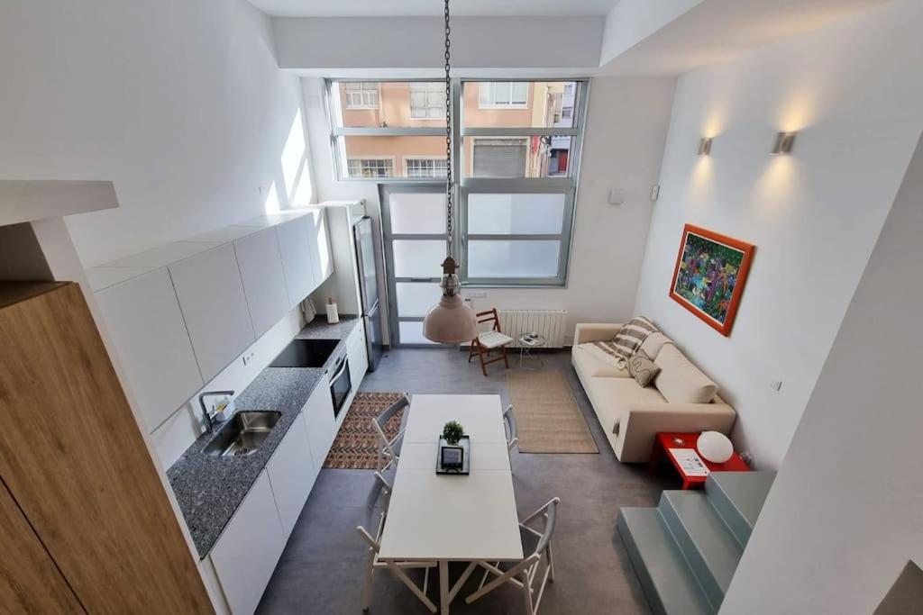 uma sala de estar com um sofá e uma mesa em Loft Filipinas Vibes Coruña em La Coruña