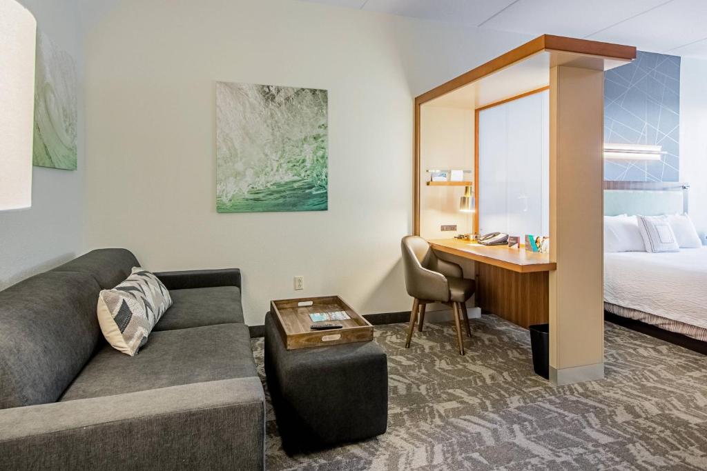 una camera d'albergo con divano, scrivania e letto di SpringHill Suites Tampa North/Tampa Palms a Tampa