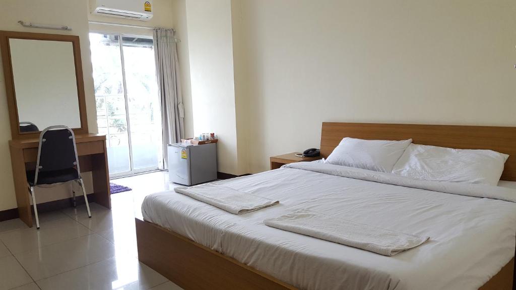 um quarto com uma cama, uma secretária e uma janela em Good Morning Apartment em Ban Bang Khan