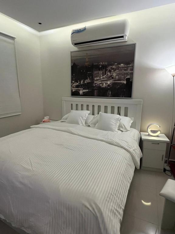 een slaapkamer met een wit bed en airconditioning bij Studio with smart entry in Riyad