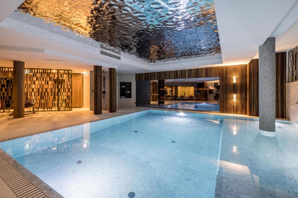 a swimming pool in a building with a ceiling at Hotel Fanat in Split