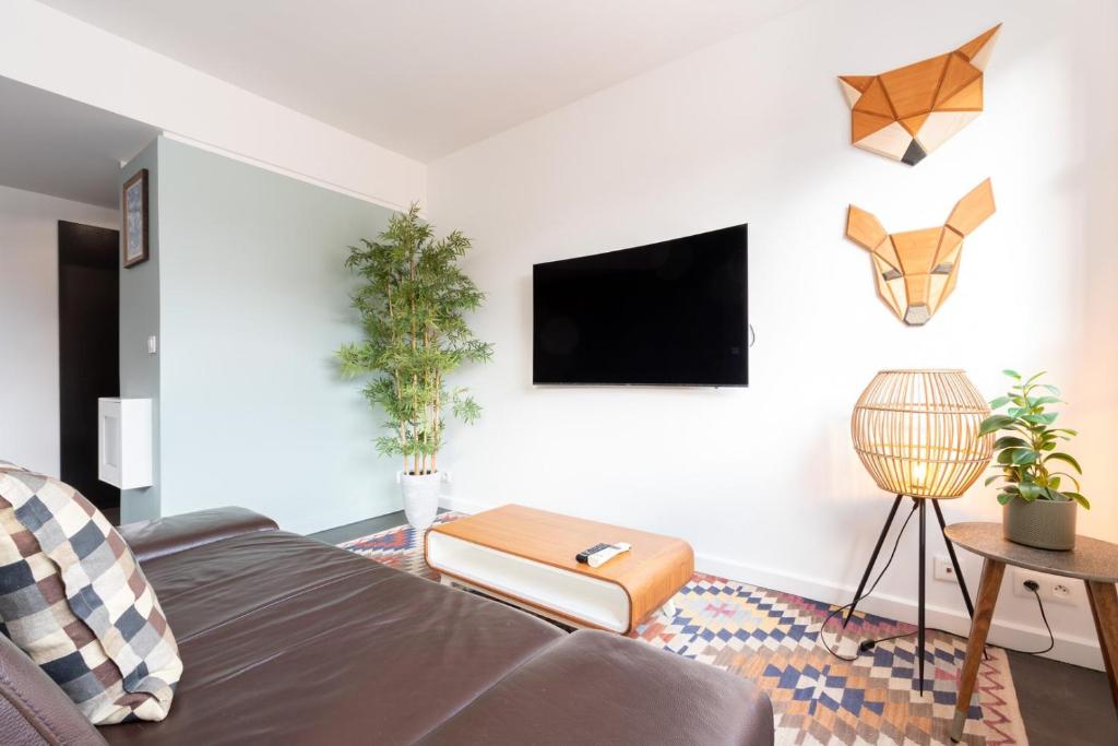 a living room with a bed and a tv at Hypercentre: apartment near station with parking in Lille