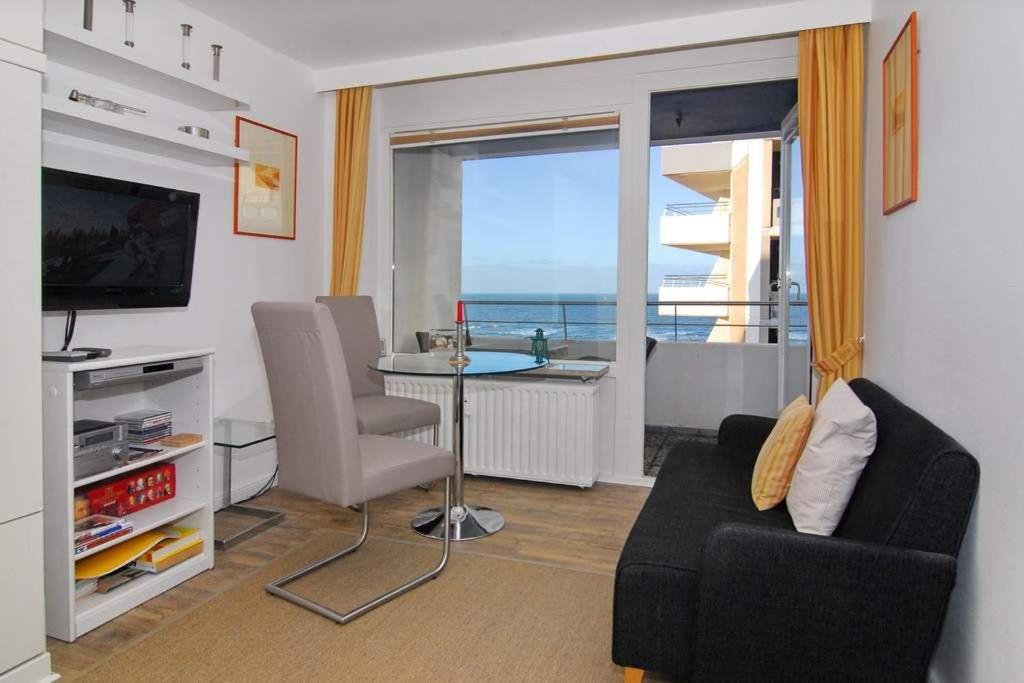 ein Wohnzimmer mit einem Tisch und Meerblick in der Unterkunft Haus am Meer, Whg 110, Seeseite in Westerland