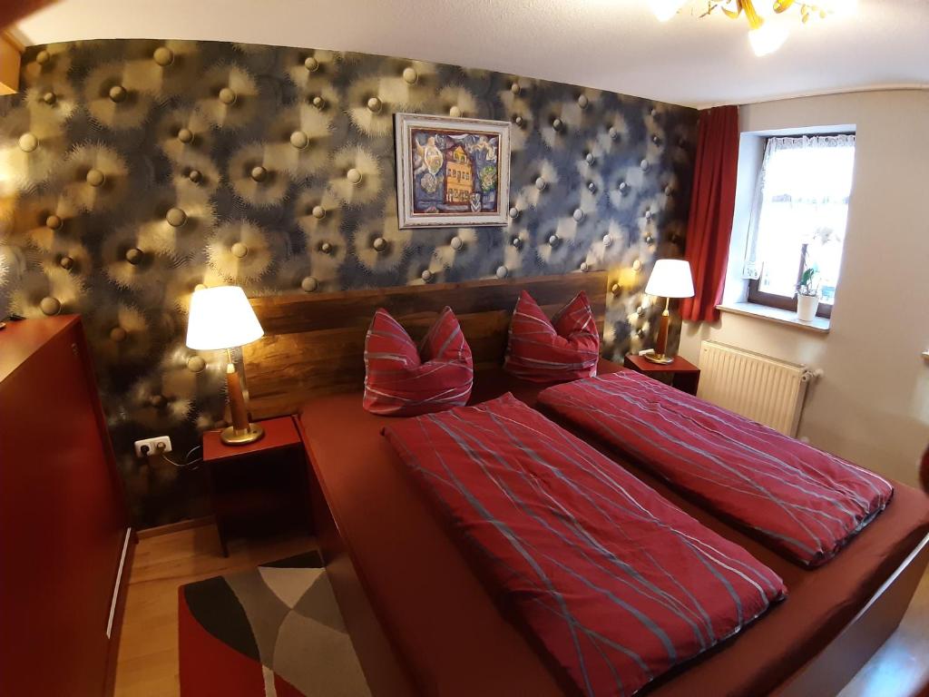a bedroom with a large red bed with red pillows at Zum kleinen Riesen in Erfurt
