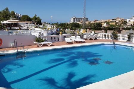een groot blauw zwembad bovenop een gebouw bij Apartamento con piscina en Las Rosas de Capistrano in Nerja