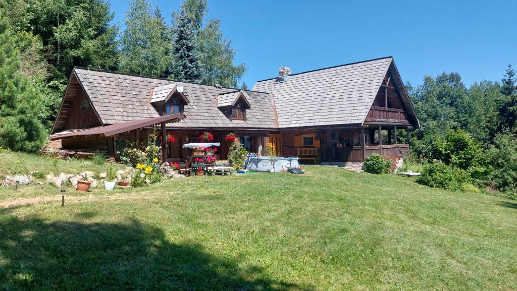 una gran casa de madera con un patio delante en Koliba Drabsko en Lom nad Rimavicou