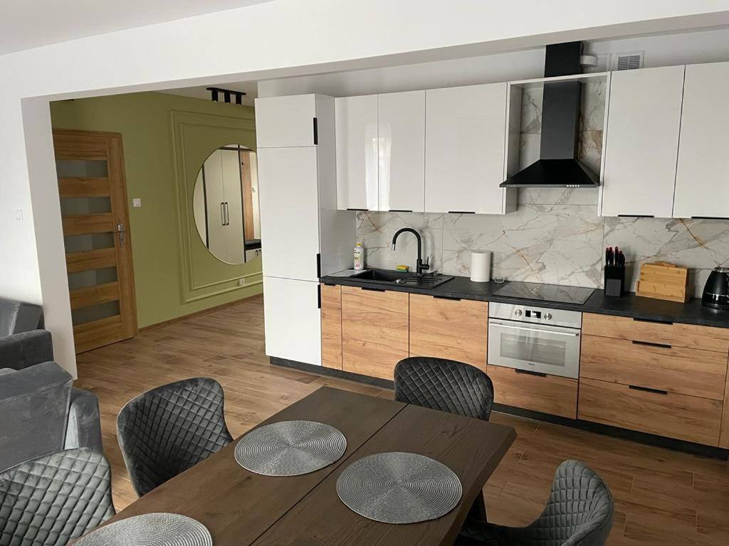 a kitchen with a table and chairs in a room at Apartament Szary 14/2 in Starogard Gdański