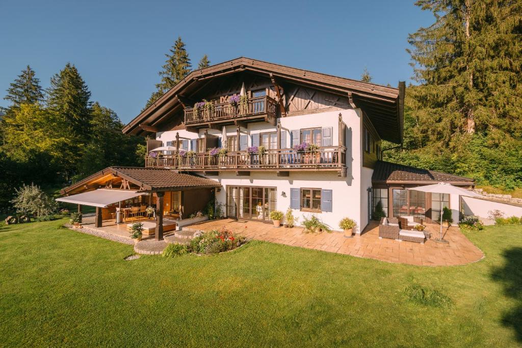 een groot huis met een balkon op een tuin bij Ferienhaus Heimhof in Garmisch-Partenkirchen