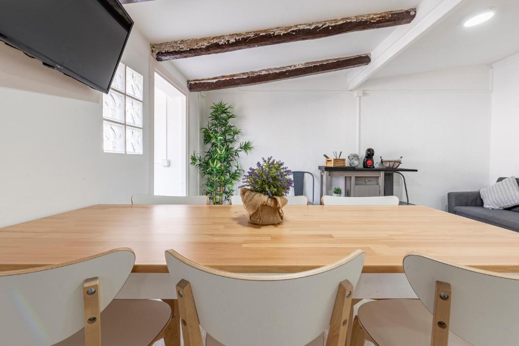 una sala da pranzo con un grande tavolo in legno e sedie di Bettatur Apartaments Rera Sant Domenech a Tarragona