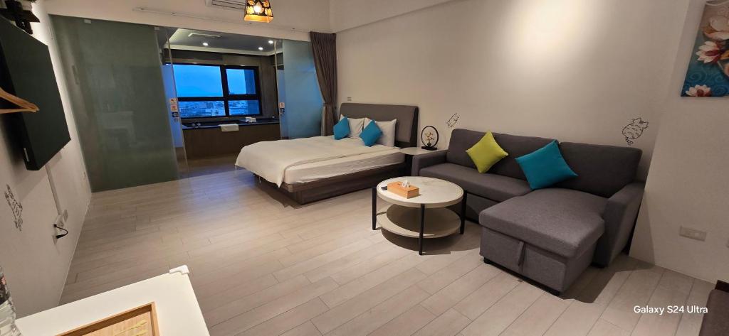 uma sala de estar com um sofá e uma cama em 楓葉閣溫泉會館Hot Spring Hotel em Hsin-hsing