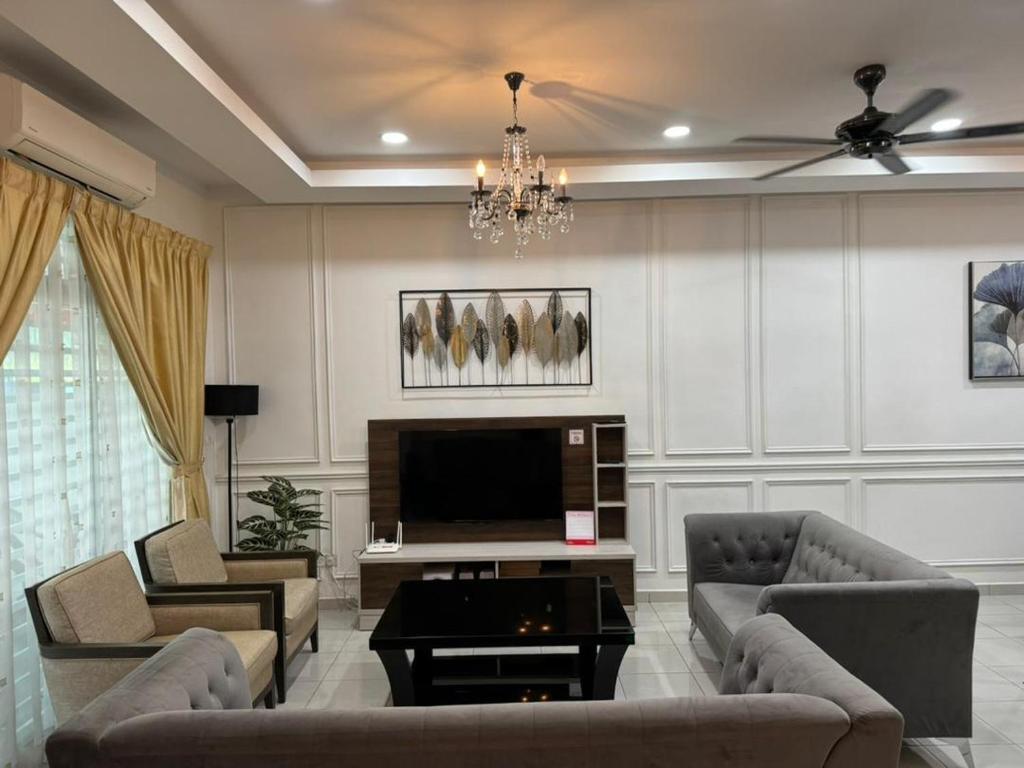 uma sala de estar com sofás e uma televisão de ecrã plano em The Amore Homestay em Muar