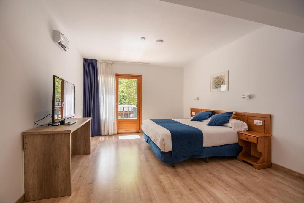 a bedroom with a bed and a television in it at Hotel Marxant in Tavascan