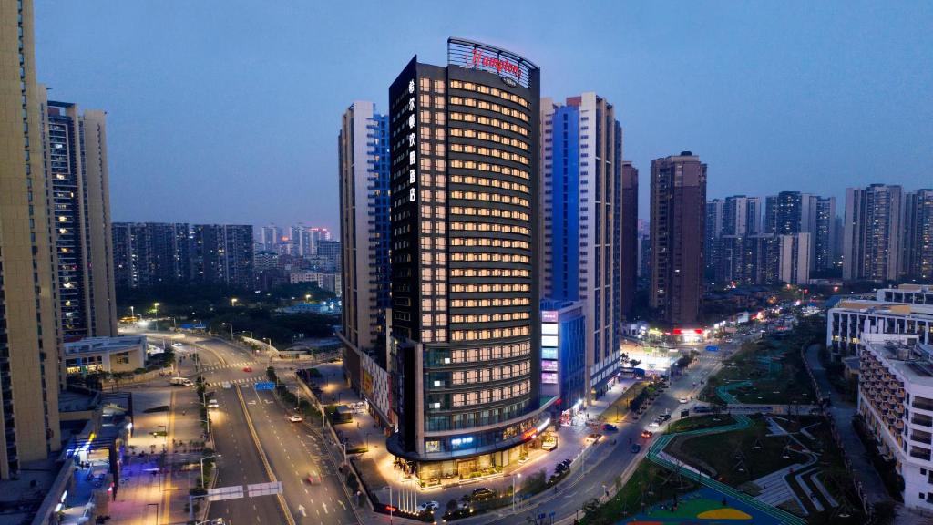 un edificio alto en una ciudad por la noche en Hampton by Hilton Shenzhen North Station en Shenzhen
