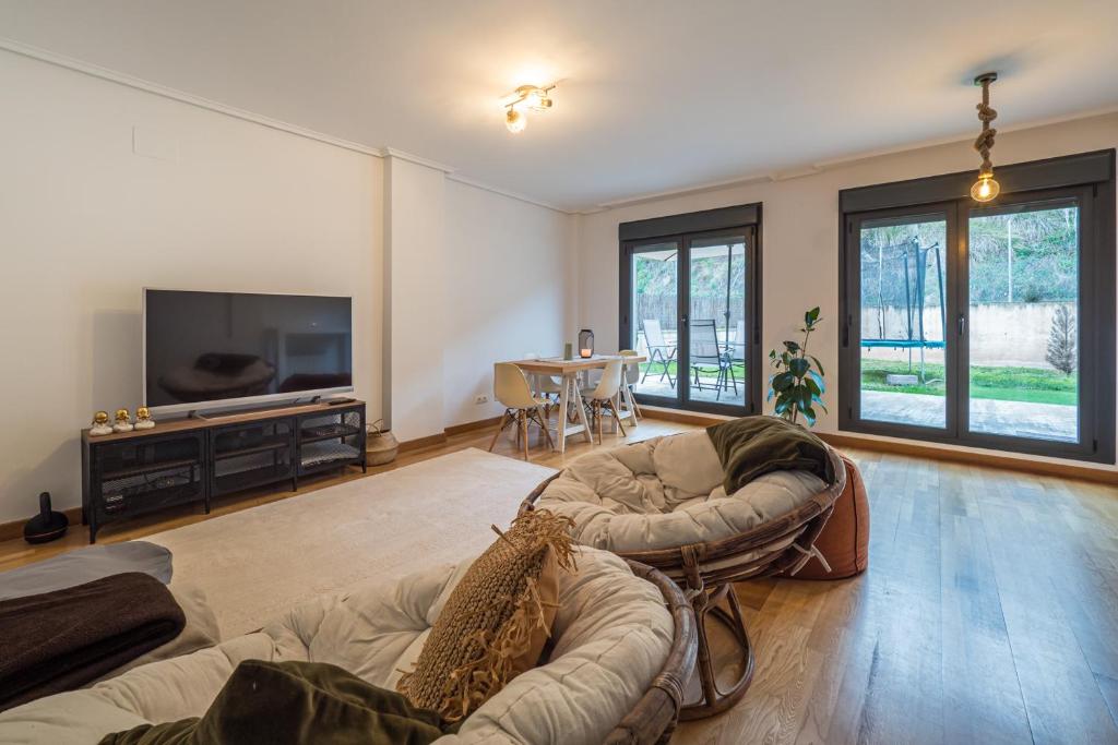 a living room with two couches and a flat screen tv at Casa Nea, tu hogar en La Rioja in Nalda