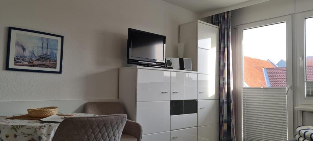 a living room with a tv on top of a dresser at Iderhoff Iderhoff 45 in Norderney