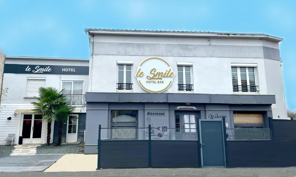 a white building with a sign that reads la smile at Hôtel Le Smile in Saint-Vincent-Sterlanges