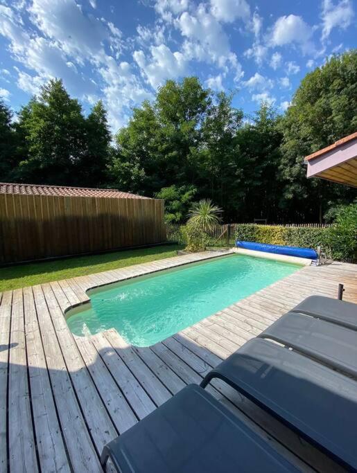 una pequeña piscina en una terraza de madera en Villa piscine privée 12 personnes, en Lacanau