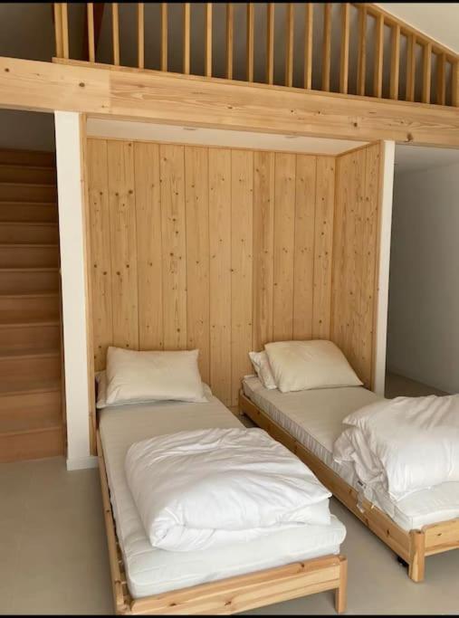 2 literas en una habitación con paredes de madera en Villa piscine privée 12 personnes, en Lacanau