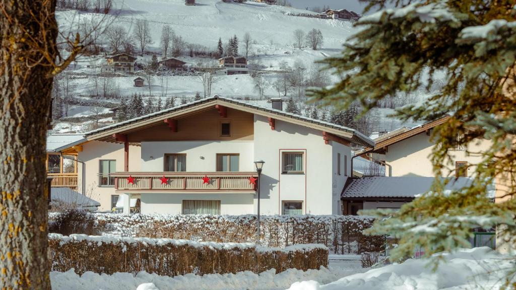 a house with a balcony in the snow at Chalet Georg in Kaprun