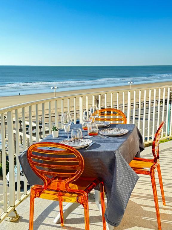 d'une table et de chaises sur un balcon donnant sur la plage. dans l'établissement T2 La vue panoramique sur l'océan à 180, à Saint-Jean-de-Monts