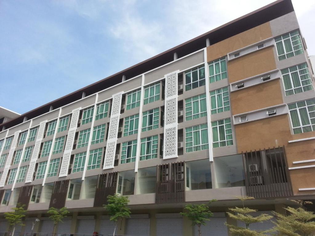 an apartment building with green windows on the side at Kota Bharu Apartment in Kota Bharu