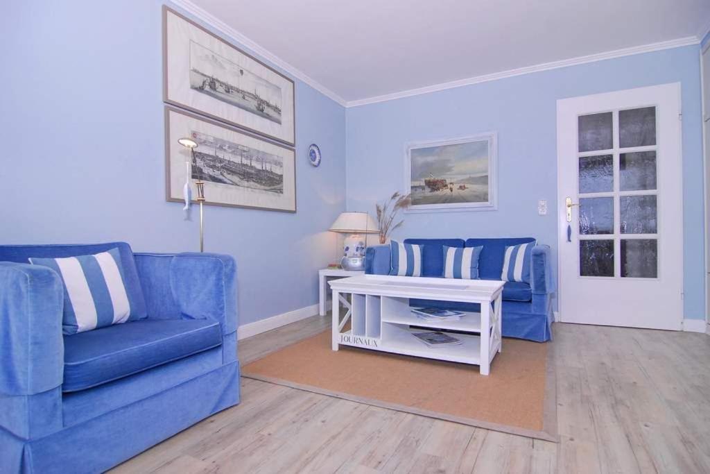 uma sala de estar com duas cadeiras azuis e uma mesa em Metropol, Whg 127, Seeseite em Westerland