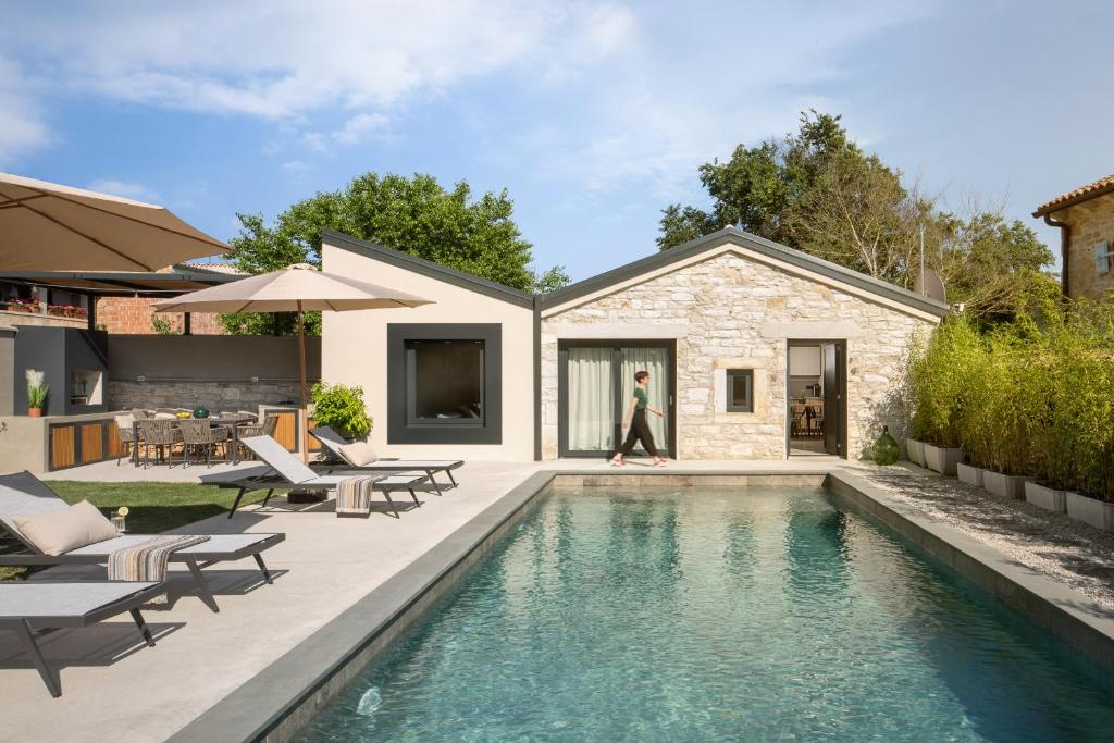 Un patio trasero con piscina y una casa. en Modern villa Bino&Marija with pool in Porec, en Kirmenjak