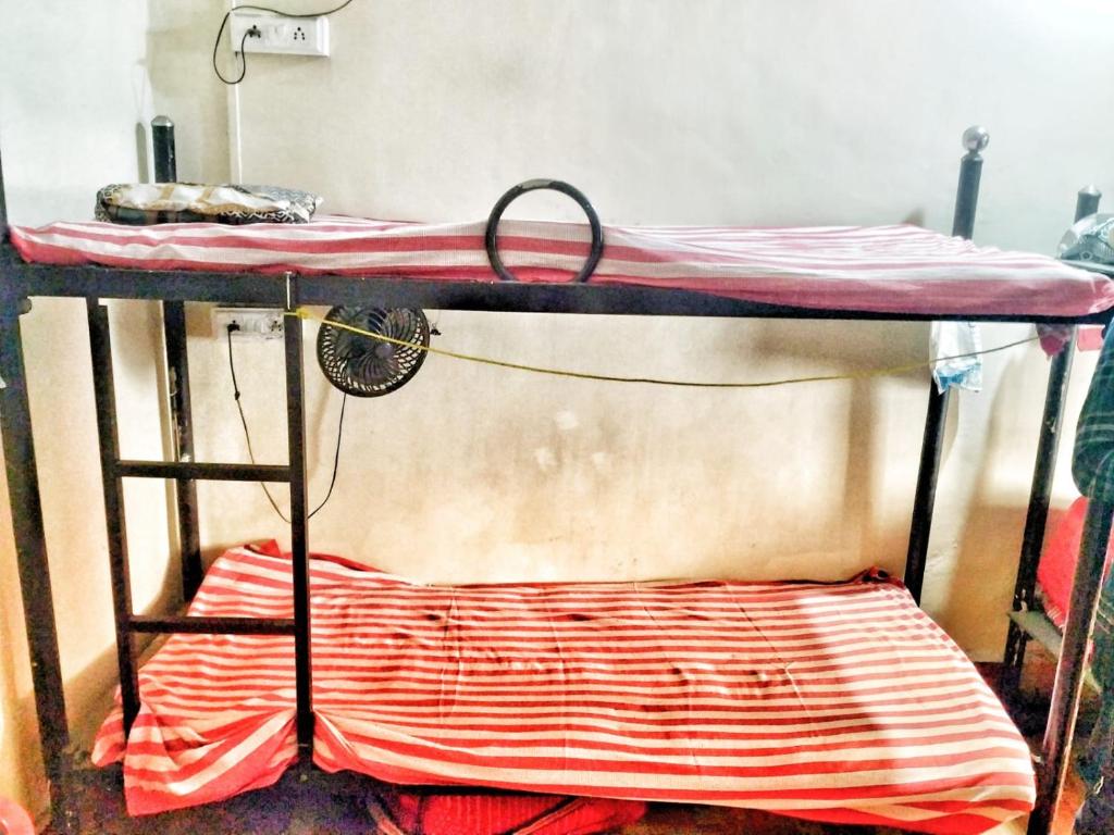 a bunk bed with a red and white blanket on it at CARE DORMITORY in Mumbai