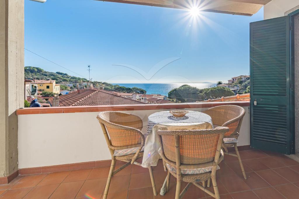 a table and chairs on a balcony with a view of the ocean at La Rondine su Seccheto - Goelba in Seccheto