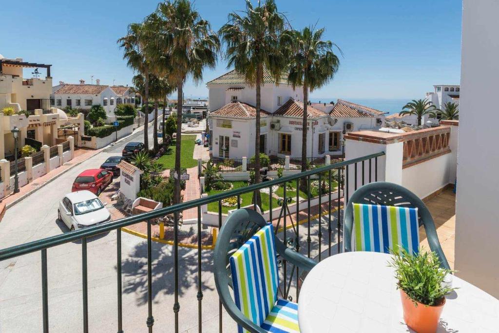 a balcony with chairs and a view of a street at Apartamento 2 Dormitorios con vistas al Mar in Nerja