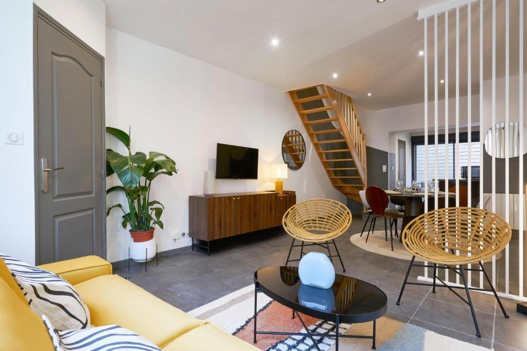 uma sala de estar com um sofá amarelo e cadeiras em 3 bedroom house with courtyard, near metro em Tourcoing