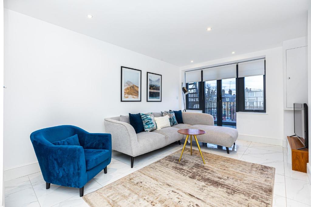 sala de estar con sofá, sillas y TV en Luxury Harley Street Apartments en Londres