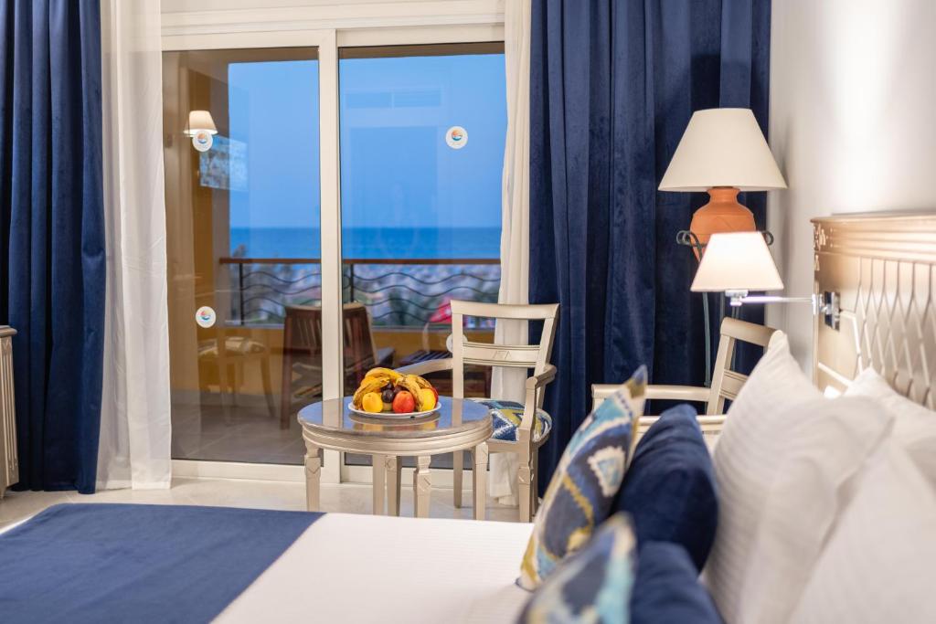 a bedroom with a bed with a bowl of fruit on a table at Malikia Resort Abu Dabbab in Abu Dabbab